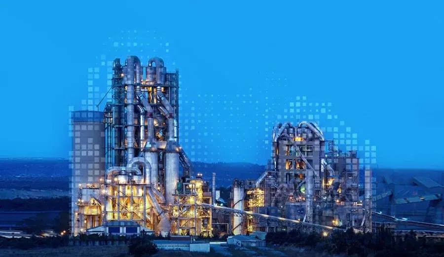 An AkçanSA cement plant lit up at dusk against a blue sky, with a rising grid of pale squares drawn over it.