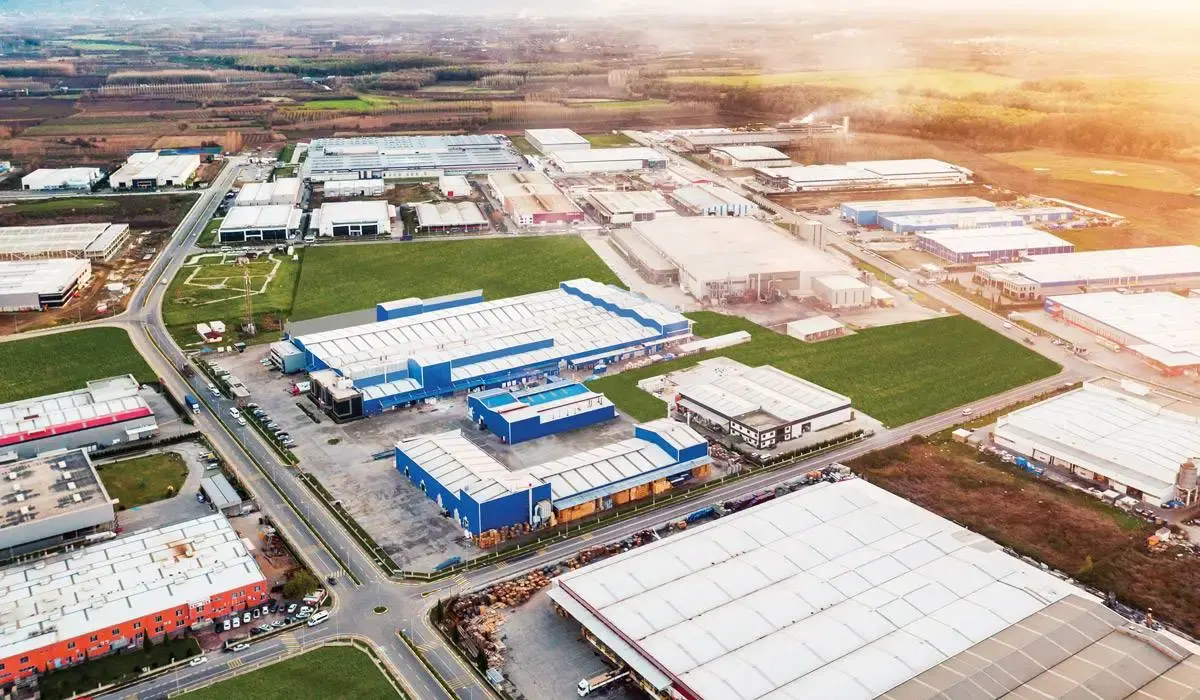 An industrial site from the air, production halls and warehouses at sunrise