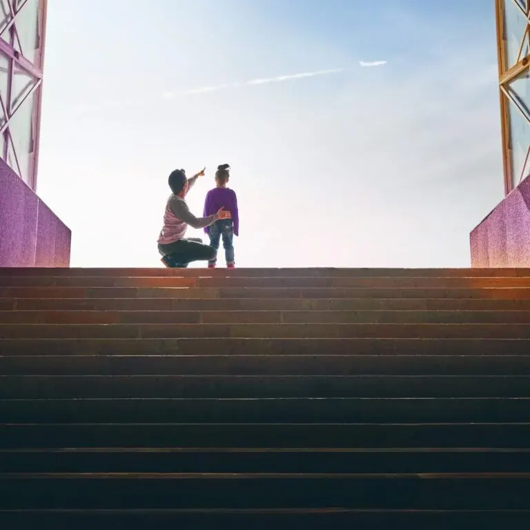 The e-book’s cover photograph: a parent kneeling at the top of a wide flight of steps, pointing something out to a child against a bright sky.