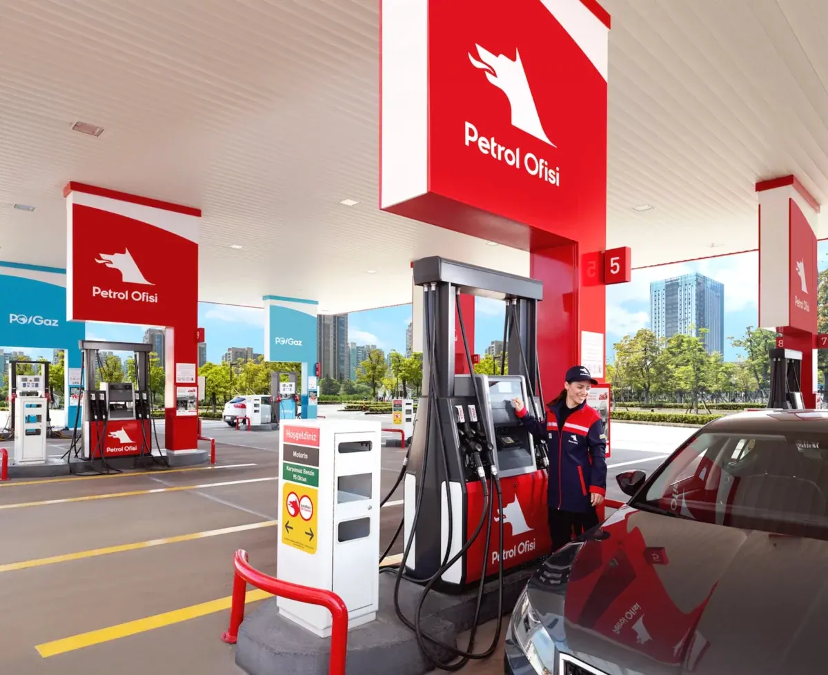 A Petrol Ofisi attendant at the pump island under the station canopy, operating the dispenser beside a waiting car.