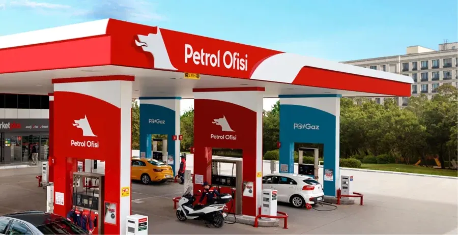 A Petrol Ofisi service station seen from the street on a clear day, its red canopy carrying the brand mark, with PO/Gaz pumps and cars refuelling beneath it.