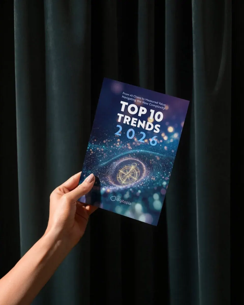 A hand holding a printed copy of the Top 10 Trends 2026 report against a dark curtain