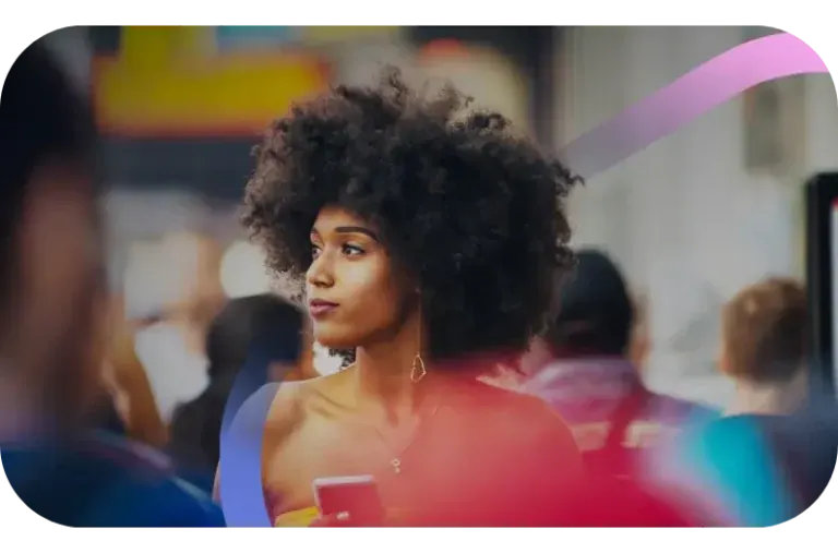 A woman looking steadily off to one side while a busy street blurs around her.