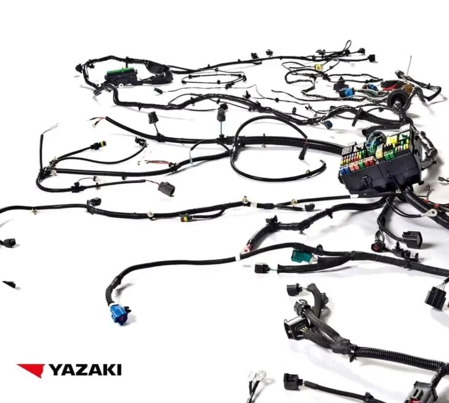 A complete Yazaki wiring harness laid out flat on a white floor, with hundreds of looms and connectors running to a fuse box.